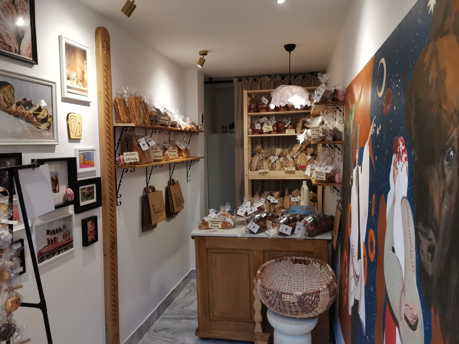 Interiorul prăvăliei dipimacu din Iași — pictura cu bourul Moldovei pe perete și rafturile cu produse